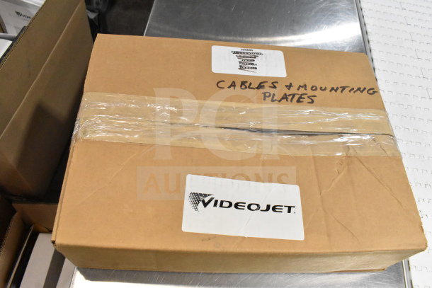 Cardboard box labeled "Cables & Mounting Plates," includes VideoJet nozzle bypass manifold kit.