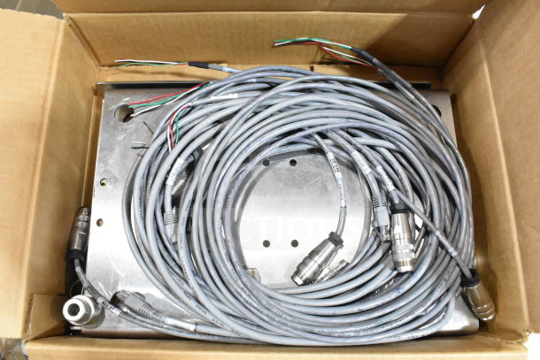 Cardboard box containing various cables with connectors, mounting plate, and parts of a VideoJet Nozzle Bypass Manifold Kit.