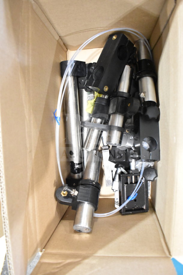 Cardboard box with various items including cables, mounting plates, and VideoJet Nozzle Bypass Manifold Kit.
