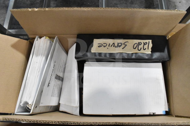 Two boxes containing various items including cables, mounting plates, and VideoJet Nozzle Bypass Manifold Kit. Sign labeled "1340 Service".