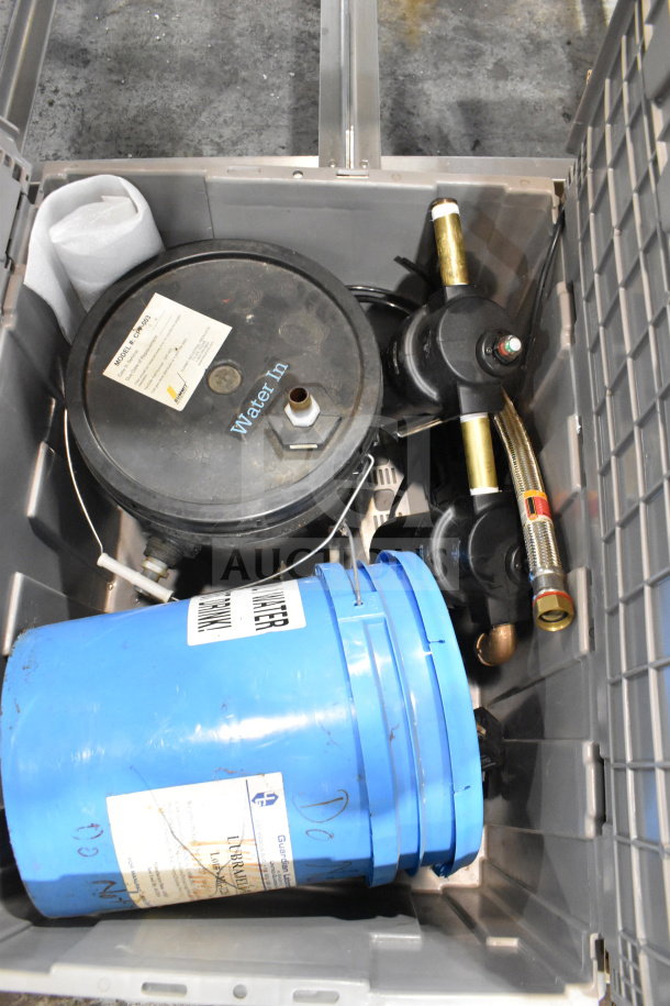 Bin containing water buckets and a water filter, featuring a blue bucket with label, and filter with "Water In" text, in good condition.