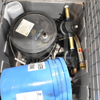 Bin containing water buckets and a water filter, featuring a blue bucket with label, and filter with "Water In" text, in good condition.