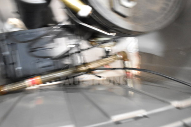 Blurred image of a bin containing water buckets and a water filter, parts indistinct. Condition and details unclear.
