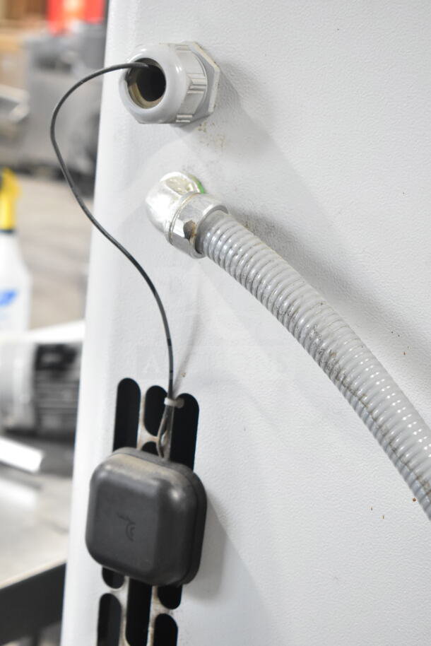 Atlas Copco GA11VSD rotary screw air compressor detail, showing hose connection and wiring. Appears in good condition.