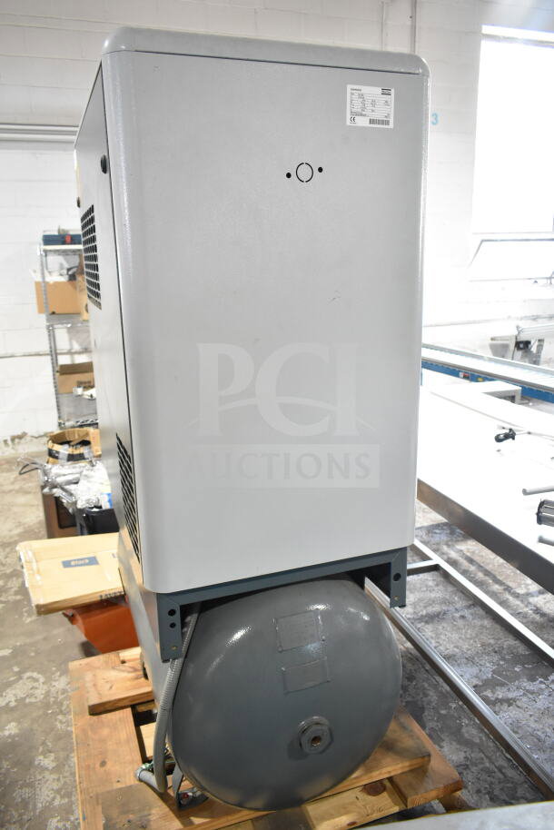 Atlas Copco GA11VSD rotary screw air compressor, gray, mounted on a pallet, with visible model label on the side.