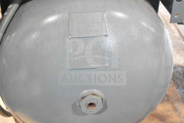 Atlas Copco GA11VSD rotary screw air compressor, gray tank with visible label markings indicating specifications and serial numbers.