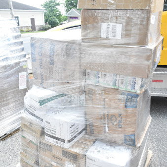 Sealed pallet with 26 assorted scratch and dent items, including napkins, paper plates, lids, and gloves.
