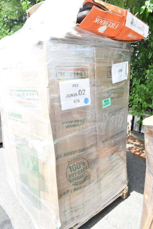 Pallet of shrink-wrapped U-Haul boxes labeled "PCI JUN26-02," containing six new scratch and dent items including a back booth.