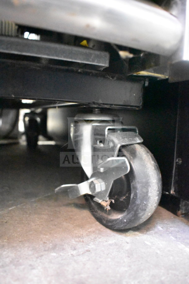 Caster wheel of 2019 True T-23F-HC commercial freezer, showing mobility feature. Black rubber wheel with locking mechanism.