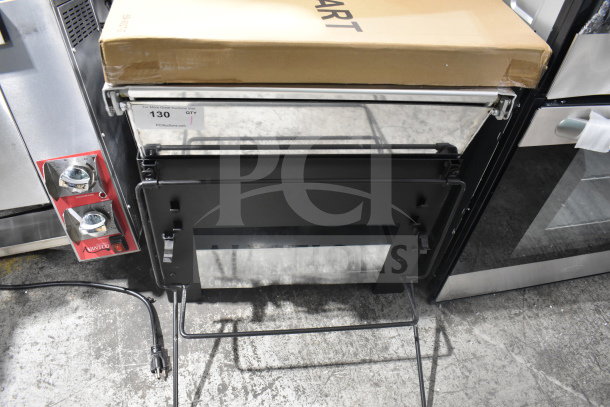 Backyard Pro Grill, new condition, features durable black metal construction. Box, labeled "Smart," is visible on top.