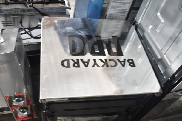 Backyard Pro Grill with stainless steel surface, bold logo on lid. New condition, sturdy design for outdoor cooking.