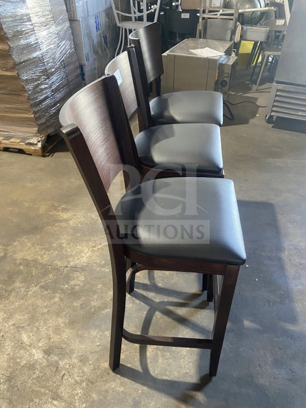 Brand new mahogany finish wood bar stool with cushion back, black vinyl seat. Ideal for commercial use, pristine condition.