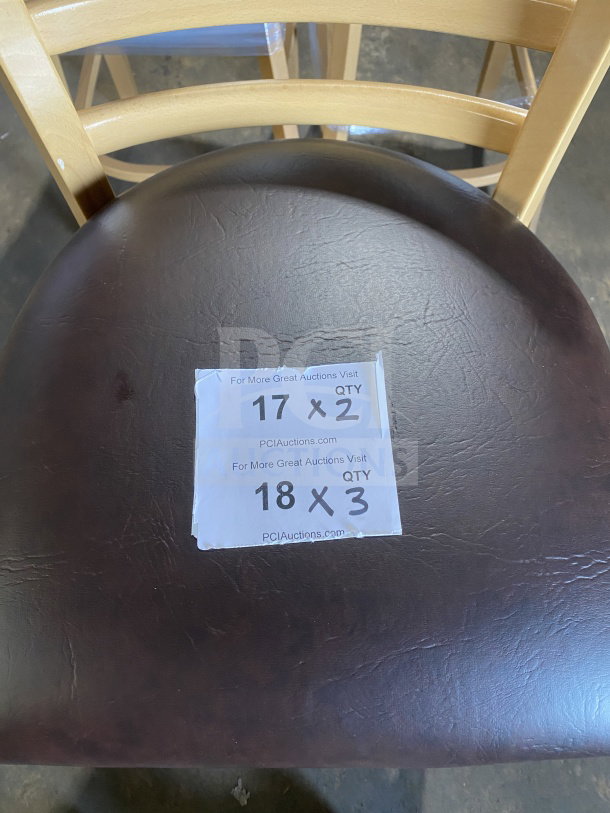 Brand new wood ladder back chair, natural finish, dark brown vinyl seat. Assembled. Includes label with auction details.