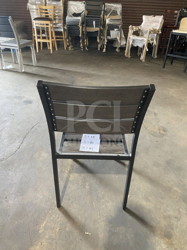 Brand new commercial outdoor teak chair with gray slats. Unused, sturdy construction. Includes dimensions tag indicating size.