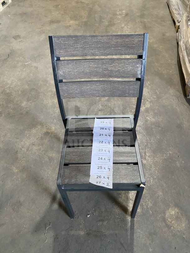 Brand new commercial outdoor teak chair with gray slats, metal frame, in excellent condition. Auction tag on seat.