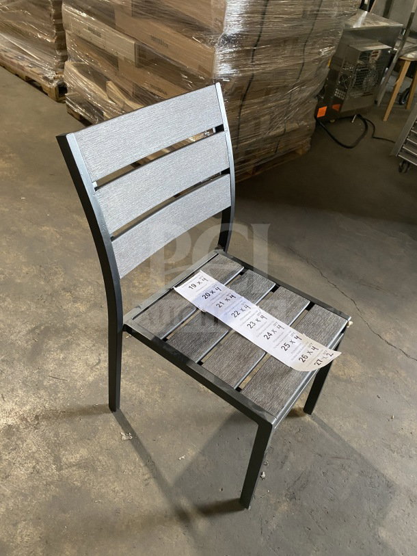 Brand new commercial outdoor teak chair with gray slats, in excellent condition. Features durable frame and modern design.