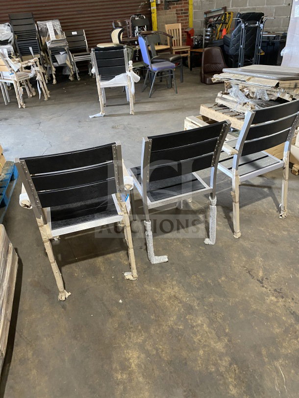 Brand new commercial outdoor teak chair with black slats, packaged. Multiple units displayed in warehouse setting.
