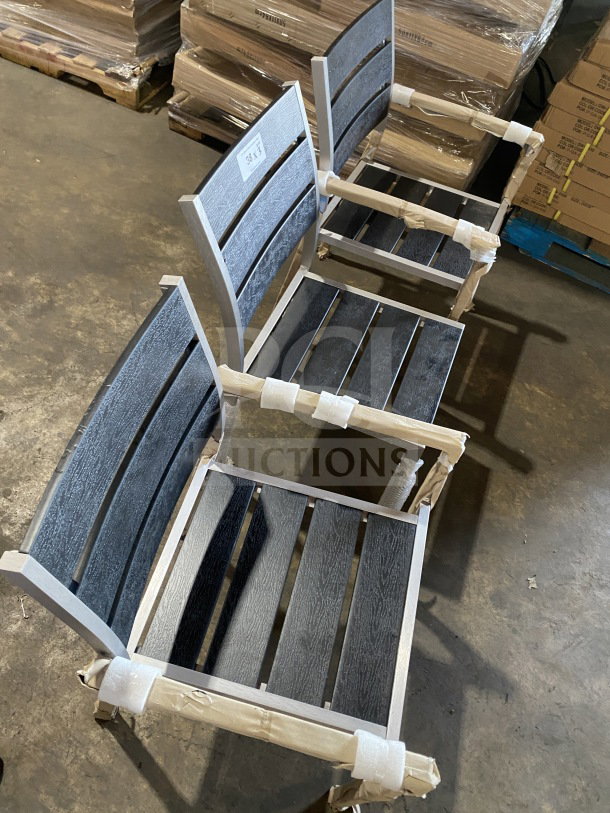 Brand new commercial outdoor teak chair with black slats, stacked, wrapped. Durable design for patios and gardens.