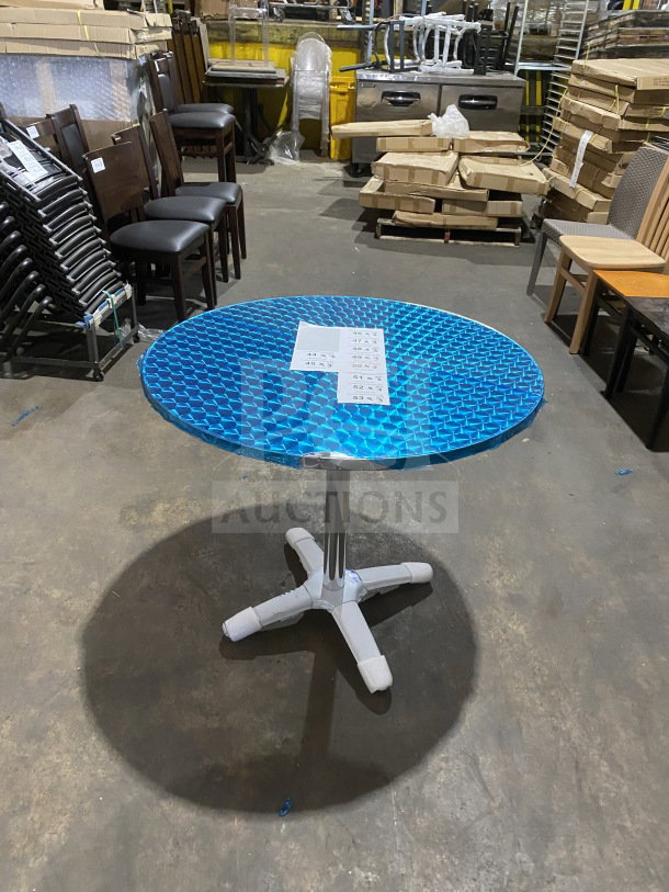 Brand new stainless steel cocktail/dining table, Model D36, with polished base and protective blue wrap.