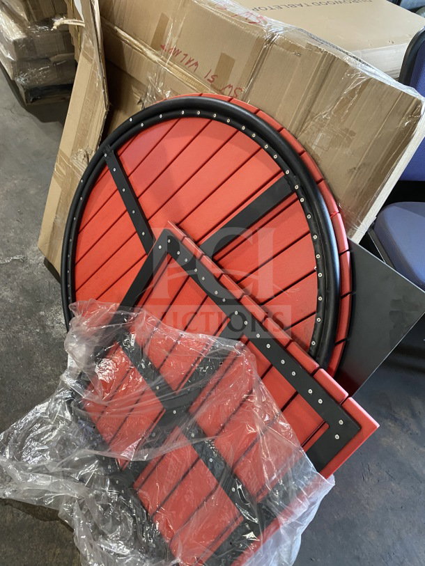Brand new red commercial restaurant and cafe table tops, round and square, partially wrapped, showing metal reinforcements.