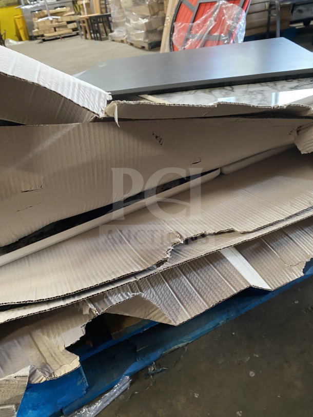Brand new commercial restaurant and café table tops in unopened boxes, showing pristine condition and packaging.