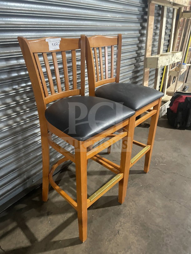 New commercial wood bar-height stool with vertical slat-back, black vinyl seat. Excellent condition, auction tag "1X2".