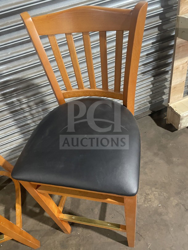 New commercial bar height stool, wooden with vertical slat-back, black vinyl seat. Ideal for bars or restaurants.