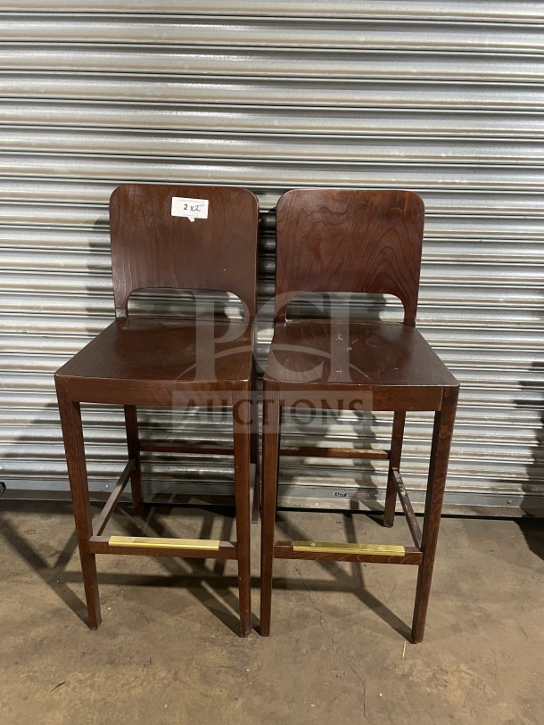 New modern style wooden bar height stools, set of two. Features dark wood finish, commercial quality, "2X" label on back.