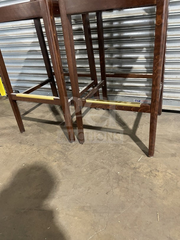 Set of new commercial modern wooden bar height stools, dark wood finish, sturdy construction, ideal for bars or cafes.