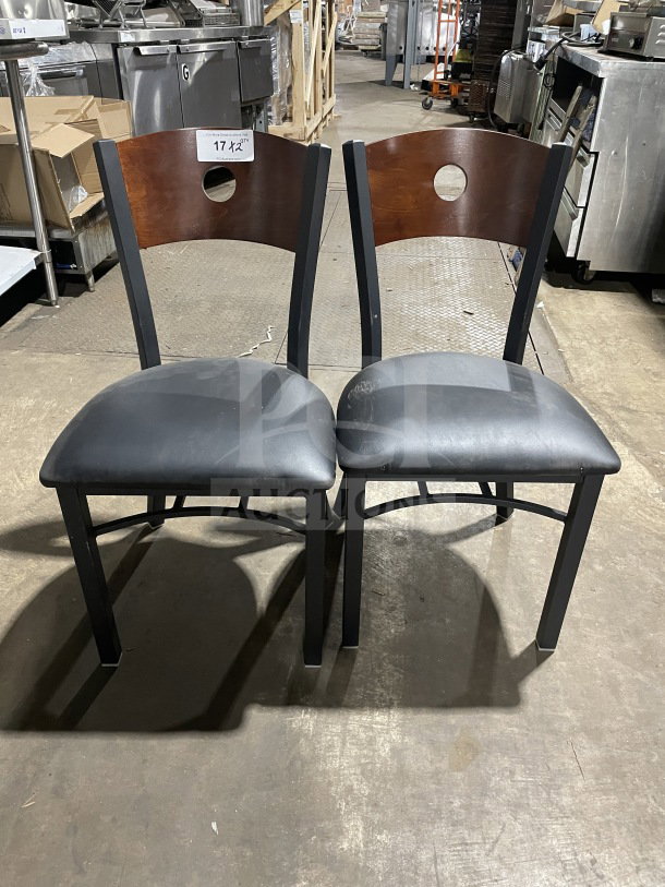 Brand new metal dining chairs with cherry wood cutout backs, black vinyl seats. Perfect condition, great for commercial use.