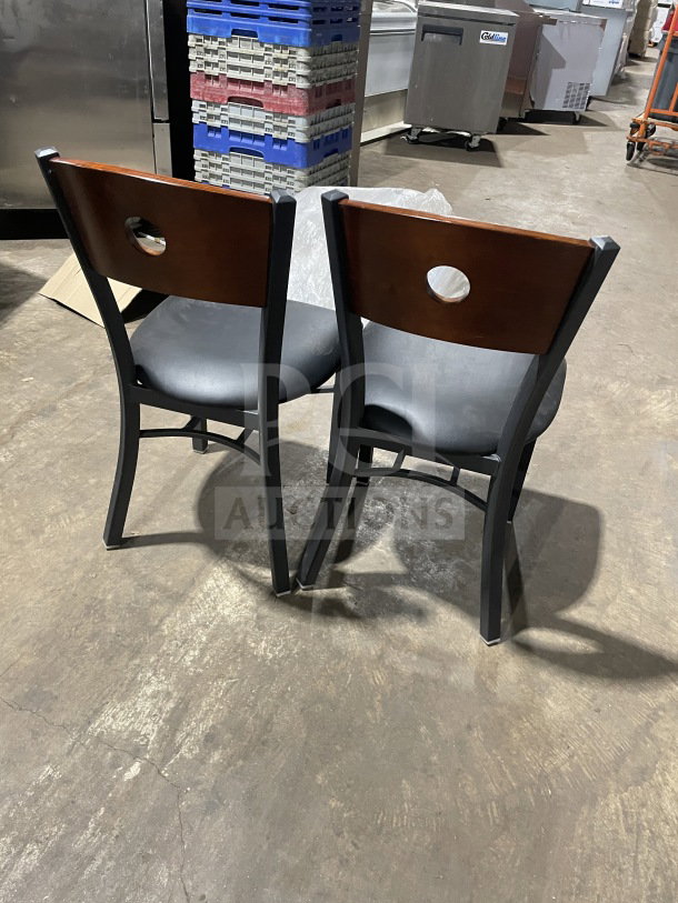 Brand new metal dining height chairs with cherry wood circle cutout backs and black vinyl seats, commercial use.