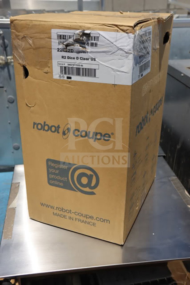 Brand new Robot Coupe R2CLR DICE food processor in damaged box, model and serial labels visible.