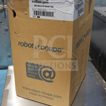 Brand new Robot Coupe R2CLR DICE food processor in damaged box, model and serial labels visible.