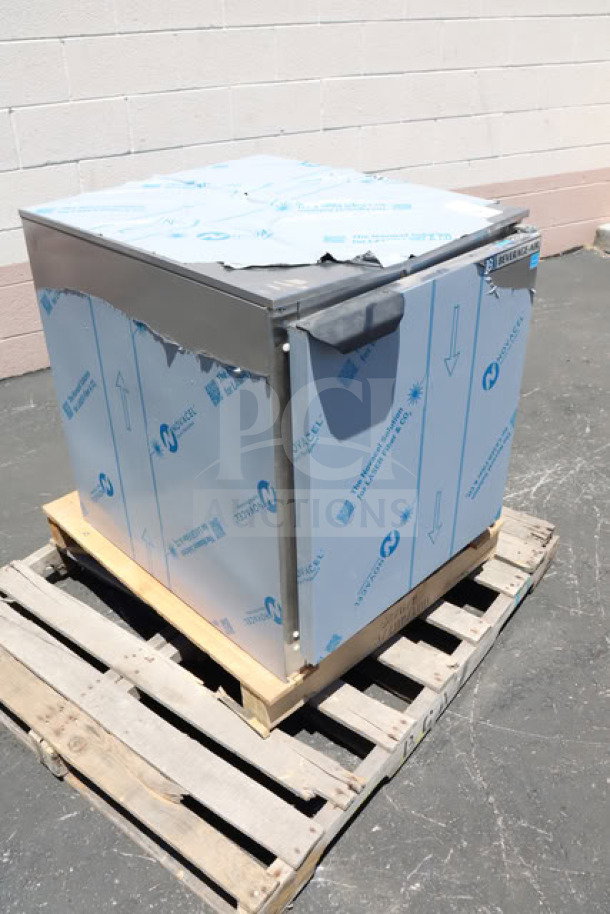 BRAND NEW Beverage-Air UCF24AHC 24" undercounter freezer on pallet, protective wrapping visible, minor scratches.