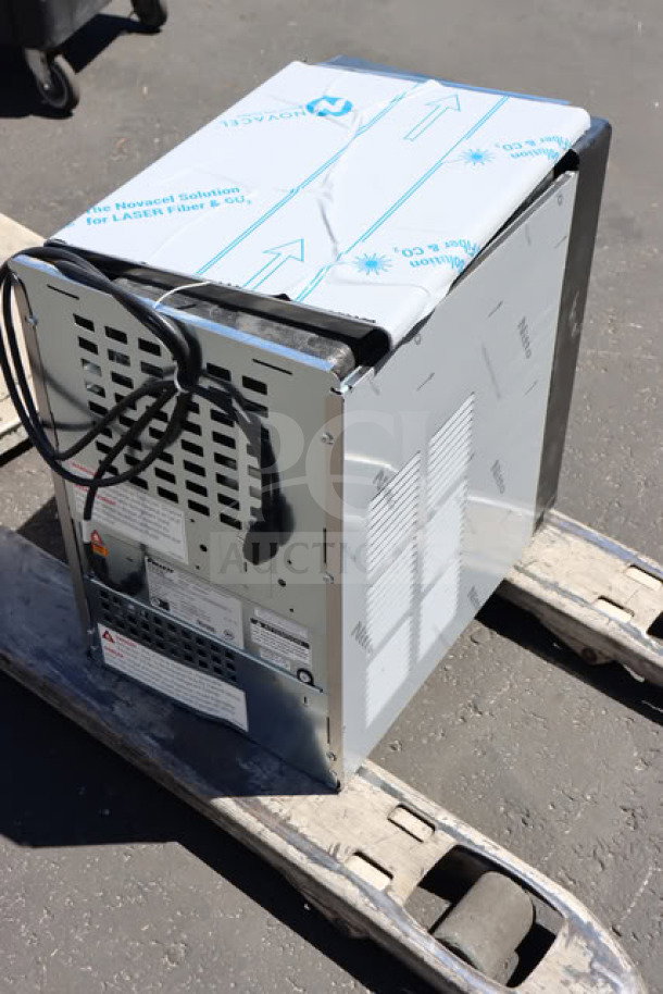 BRAND NEW SCRATCH-N-DENT Follett 15CI114A-IW-NF-ST-00 Champion 15 Series ice maker on wooden pallet, rear view.