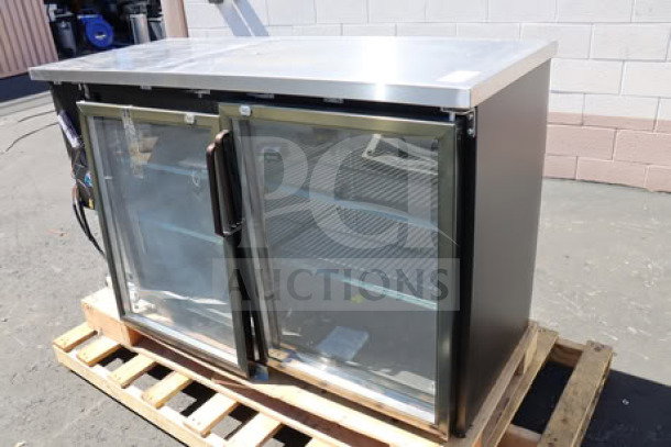 Brand new Avantco UBB-60G-HC 60" black back bar refrigerator with glass doors, LED lighting, on a pallet.