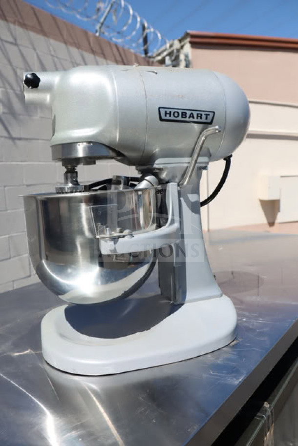Brand new Hobart N50-60 5 Qt. mixer, silver, 120V, 1/6 hp, with bowl lift and standard accessories; minor scratches visible.