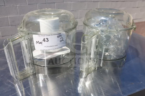 Two clear Robot Coupe food processor bowls on a metal surface, each with handles; auction label indicates quantity 2.
