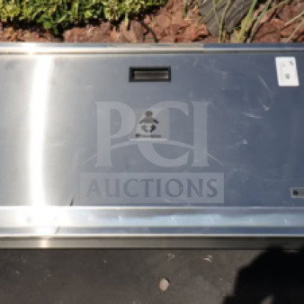 Stainless steel baby changing station, wall-mounted, with child icon label, excellent condition, slight surface marks visible.