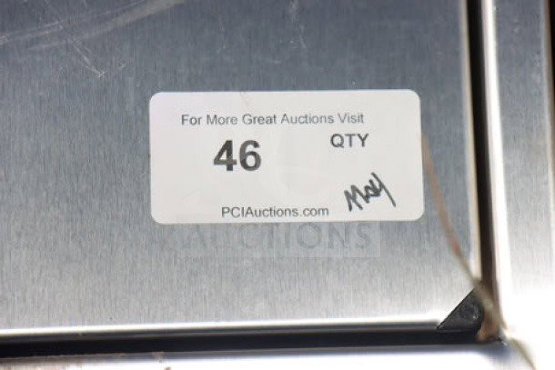Metal baby changing station featuring a label with auction details "46 QTY," indicating auction source and item number.