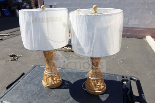 Brand new set of two SAFAVIEH Magnus table lamps, model TBL4306A, bamboo bases, wrapped shades, tags visible, out of box.