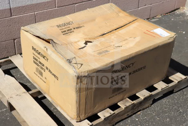 Brand new Regency 28"x20"x12" stainless steel sink, model 600DI12812, in original packaging on pallet.
