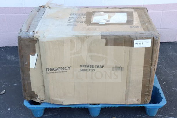 Regency 600GT35 grease trap in original box, 70 lb. capacity, 35 GPM, PDI certified, non-threaded connections, visible wear on box.
