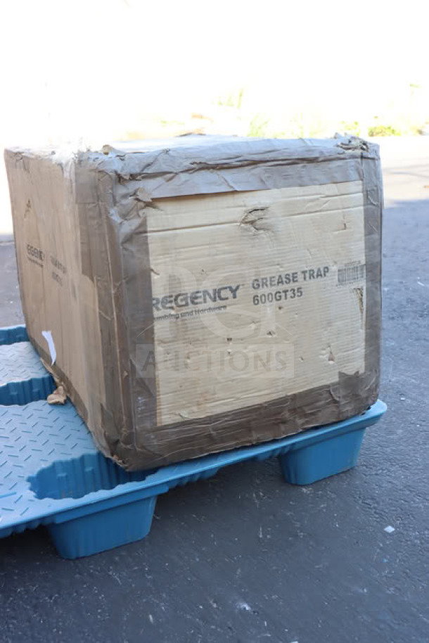 New Regency 600GT35 70 lb. grease trap in box, 35 GPM, non-threaded connections, PDI certified, on blue pallet.