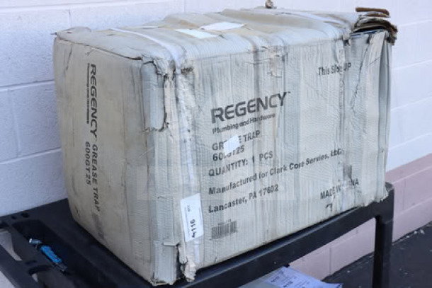 Regency grease trap model 600GT25 in damaged original packaging, 50 lb. capacity, 25 GPM, 3" non-threaded connections.