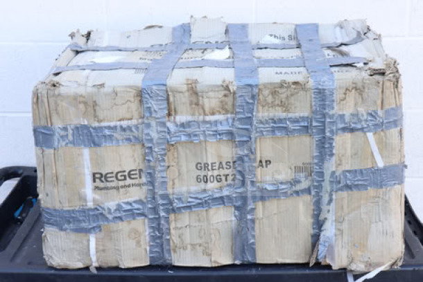 Regency 600GT20 40 lb. grease trap with damaged packaging, secured with duct tape. PDI certified, visible label.