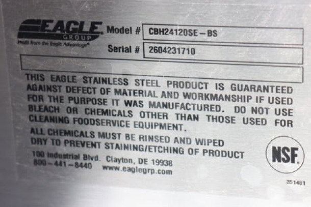 Alt text: Eagle Group work table label showing model CBH24120SE-BS, serial 2604231710, materials guarantee, and NSF certification.