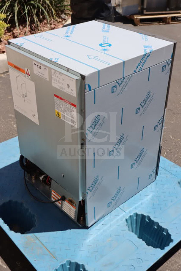 Manitowoc UDP-0080A-161 ice machine with blue protective wrapping, new condition, includes sliding door inside unit.