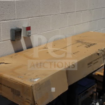 Regency 600TB2484G stainless steel work table in original packaging, featuring 24"x84"x18 gauge size, with backsplash, galvanized legs, and undershelf.