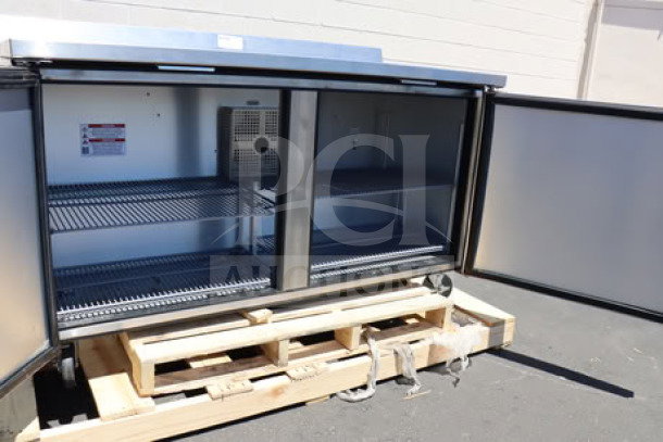 True TWT-60F-HC 60 3/8" worktop freezer with 3 9/16" backsplash, open doors, shelves visible, on a pallet.